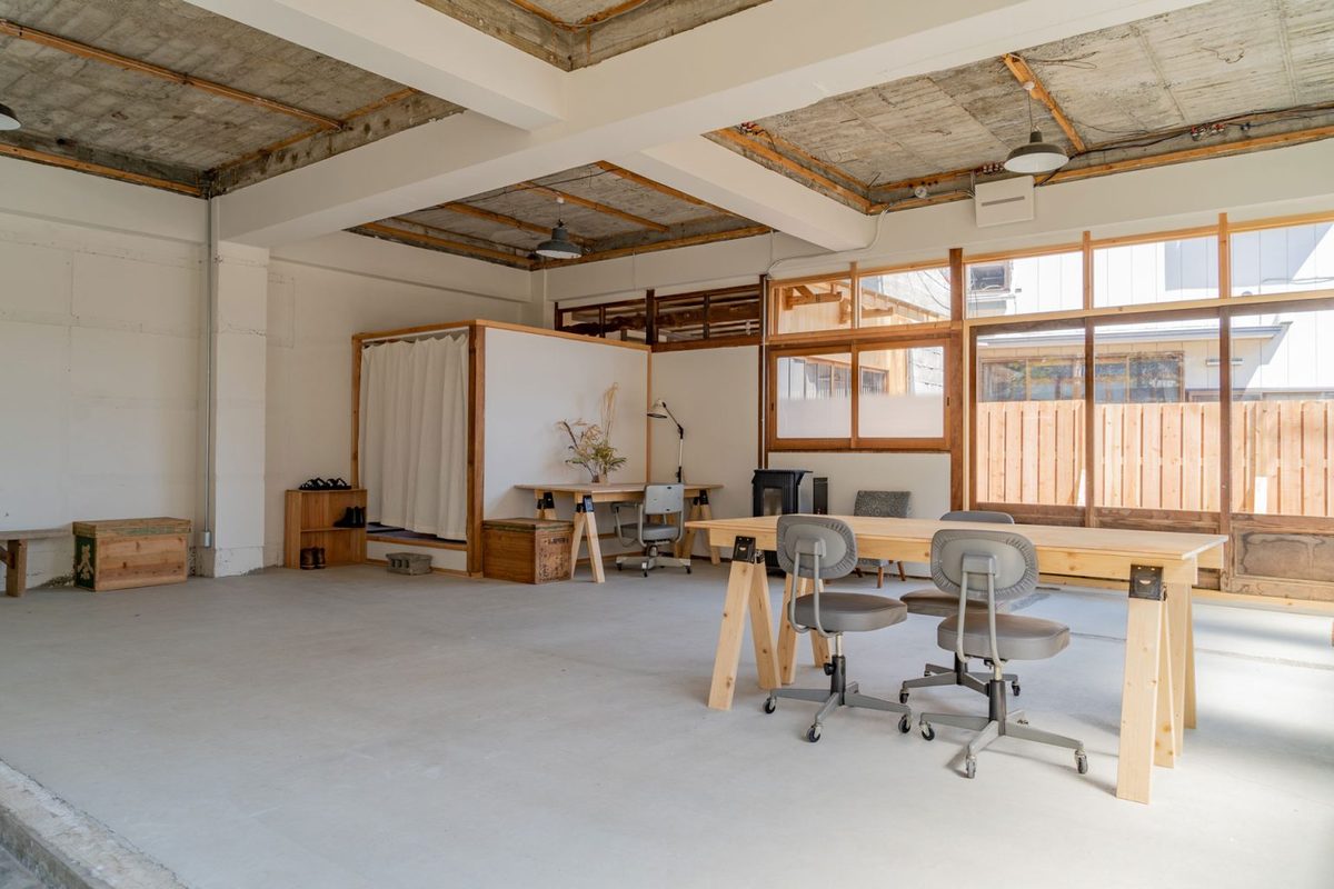 A bright studio space with wooden work tables and chairs